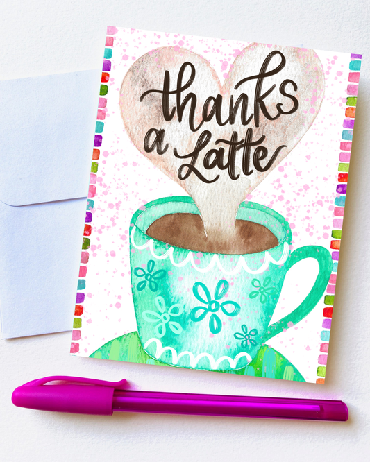 Greeting card with a heart-shaped foam design and 'thanks a Latte' text, next to a pen on a white background.